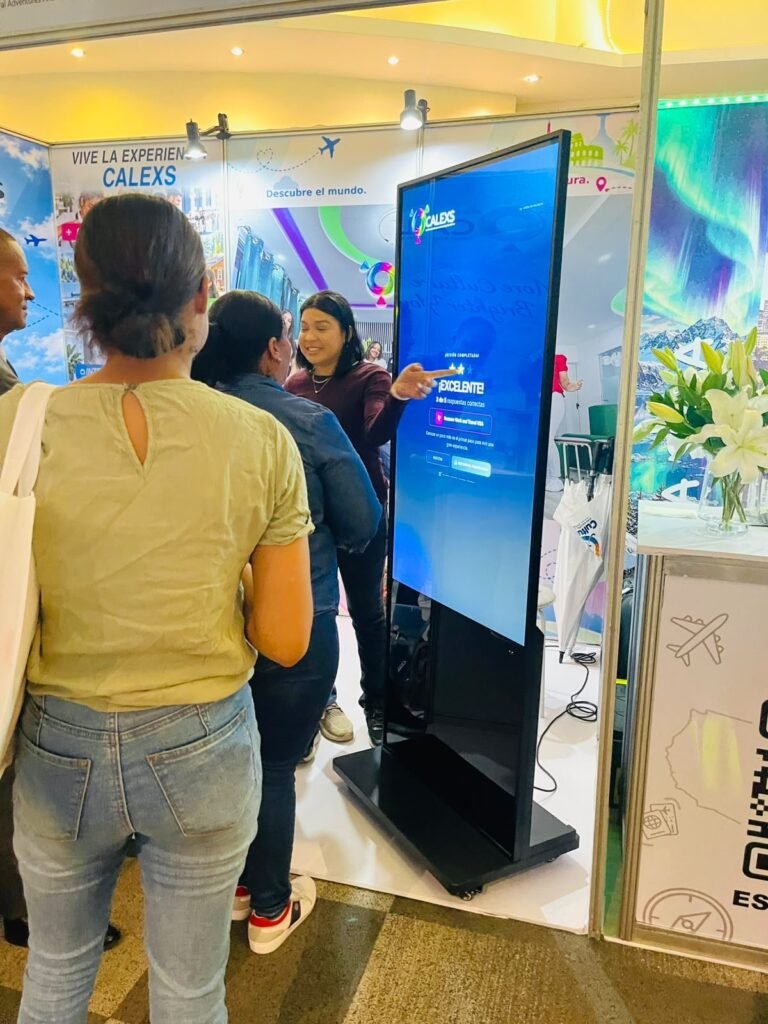 Participantes jugando una trivia en un tótem táctil de Digital Sign RD en el stand de Calexs